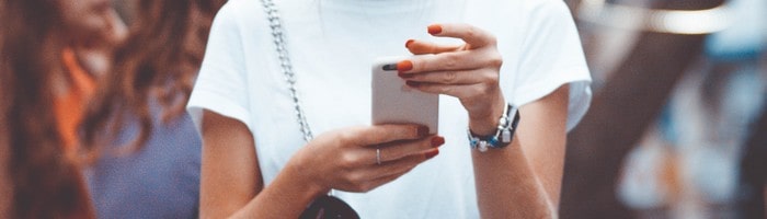 Femme tenant dans les mains un téléphone mobile