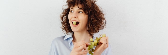 Femme mangeant du raisin - résilier la mutuelle CIC